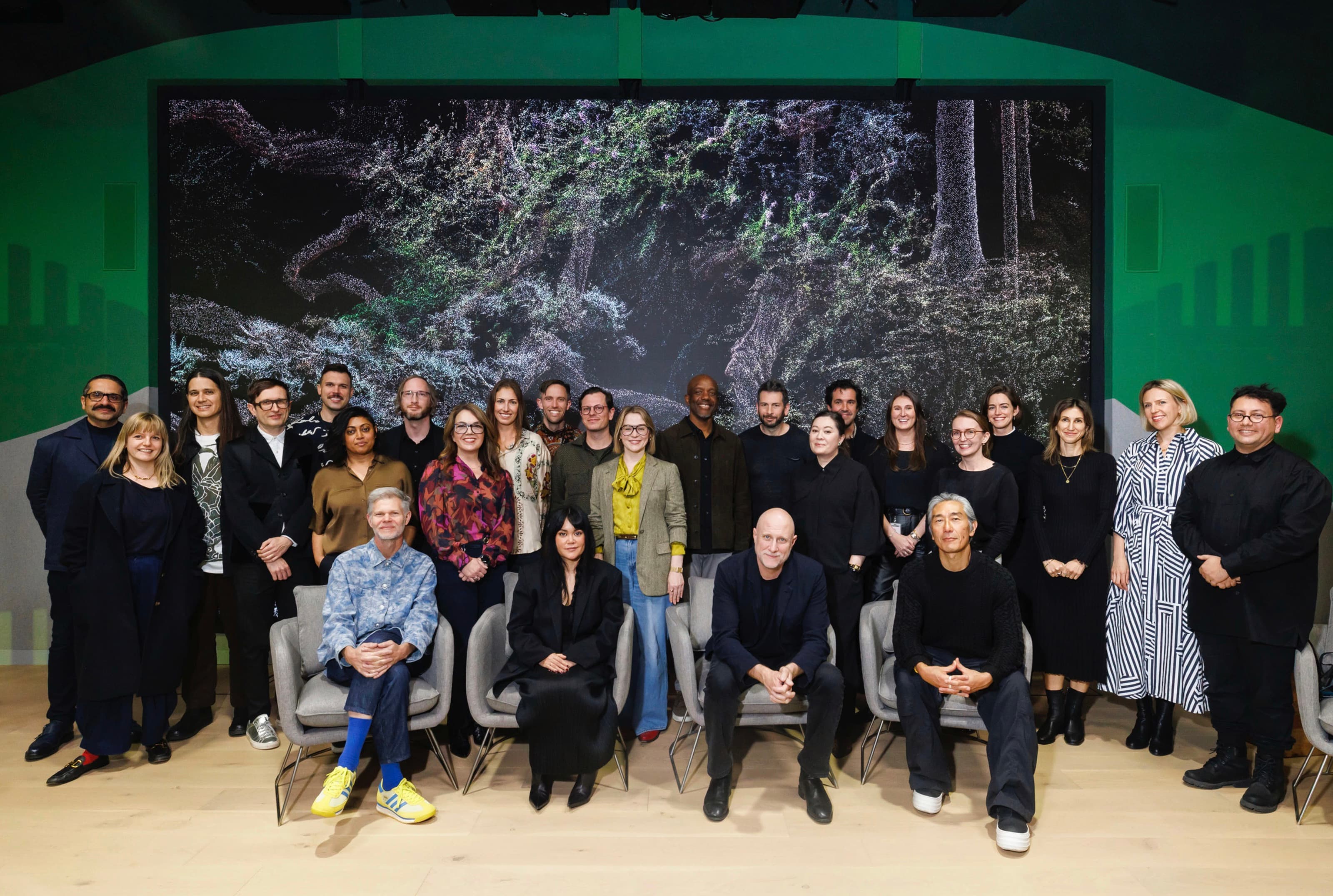 Gradient Canvas artists and project collaborators gathered in front of a digital forest artwork